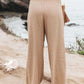 Flowy tan pants with smocked waist and wide leg design
