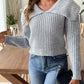 Casual gray cable-knit sweater worn with high-waisted denim jeans.
