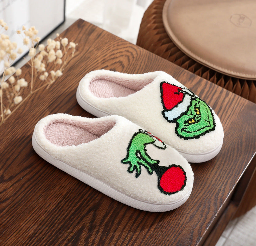 Embroidered Grinch slippers with Santa hat and festive ornament detail
