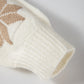 Close-up of an ivory knit sweater with a festive snowflake pattern, designed for warmth and comfort during the holidays.