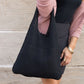 Minimalist black knit hobo bag, perfect for casual outings.
