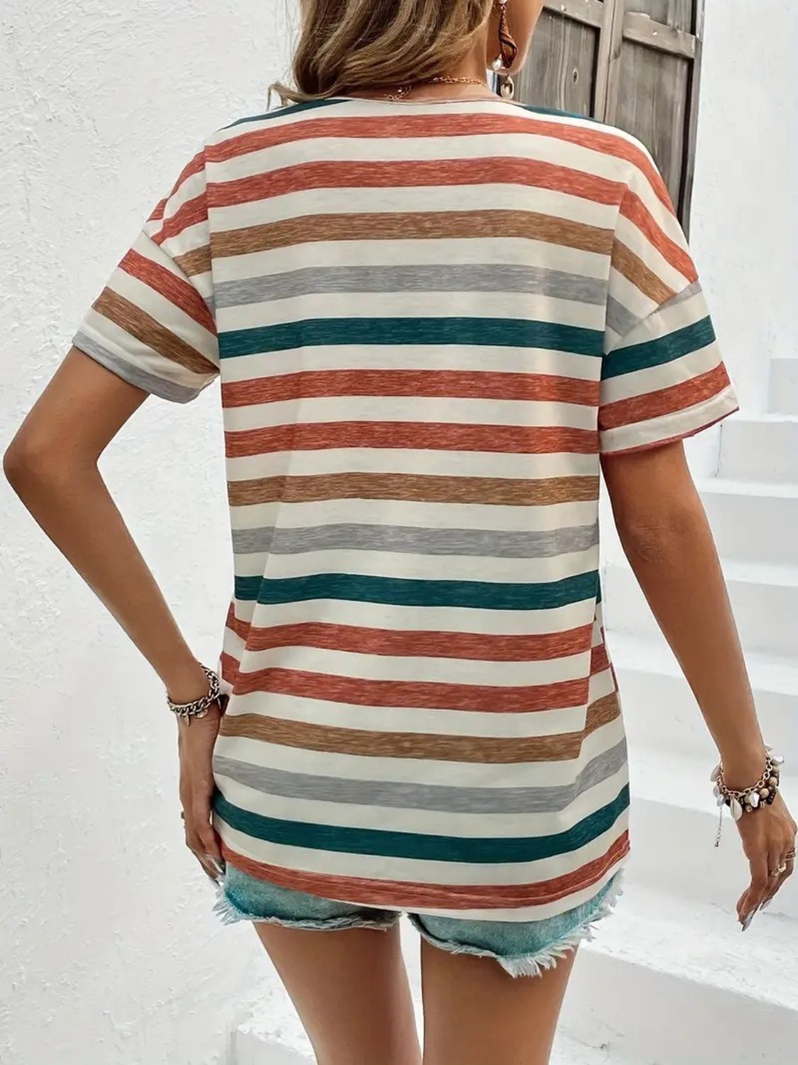 Comfortable striped t-shirt in warm earthy tones, styled with denim for a casual vibe
