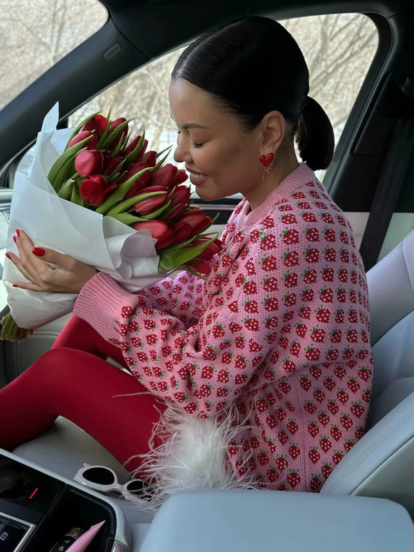 Soft pink strawberry sweater featuring a fun pattern, perfect for adding a touch of sweetness to your wardrobe.