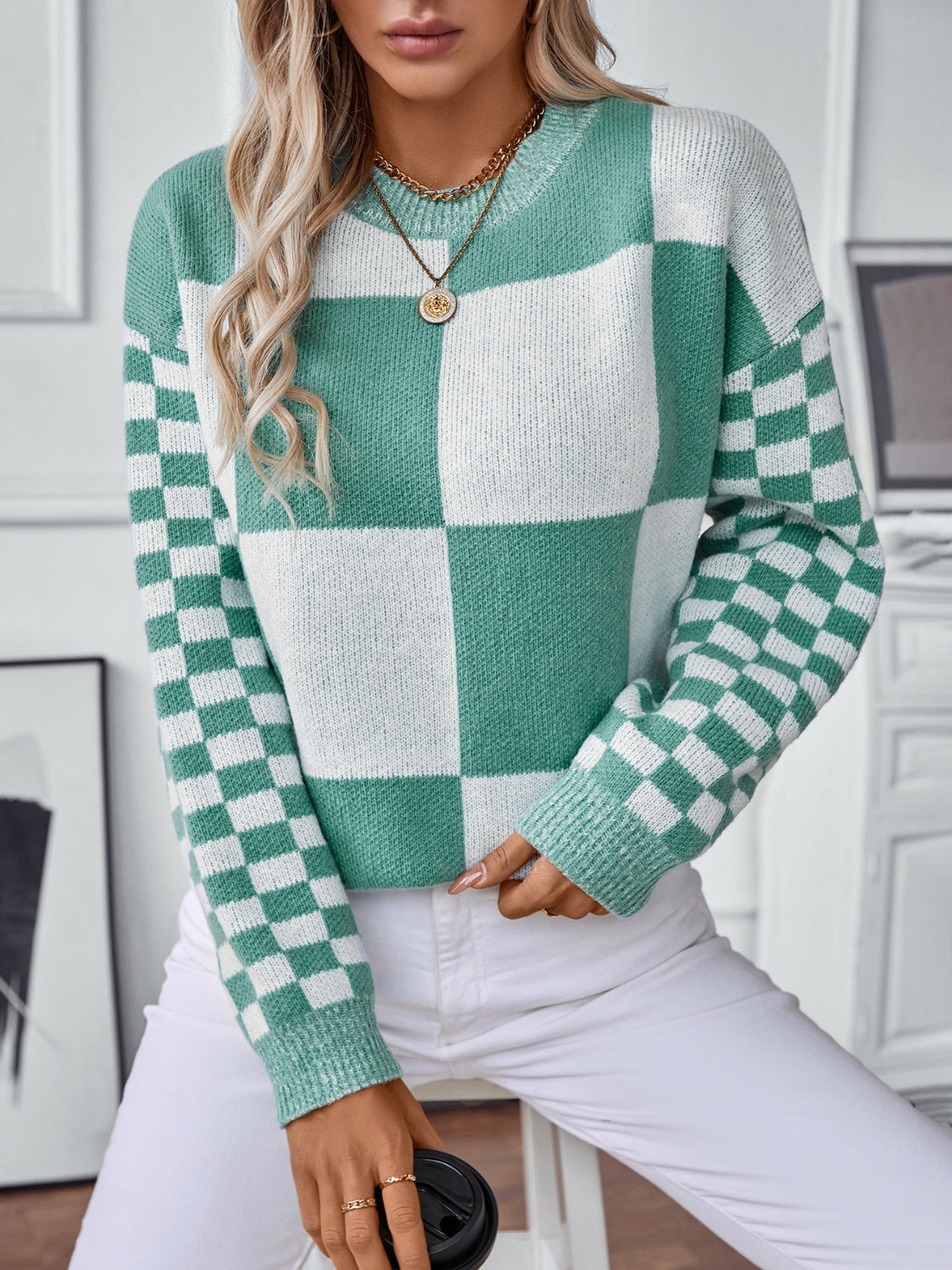 Modern turquoise sweater featuring a unique mix of checkerboard and color-block designs.
