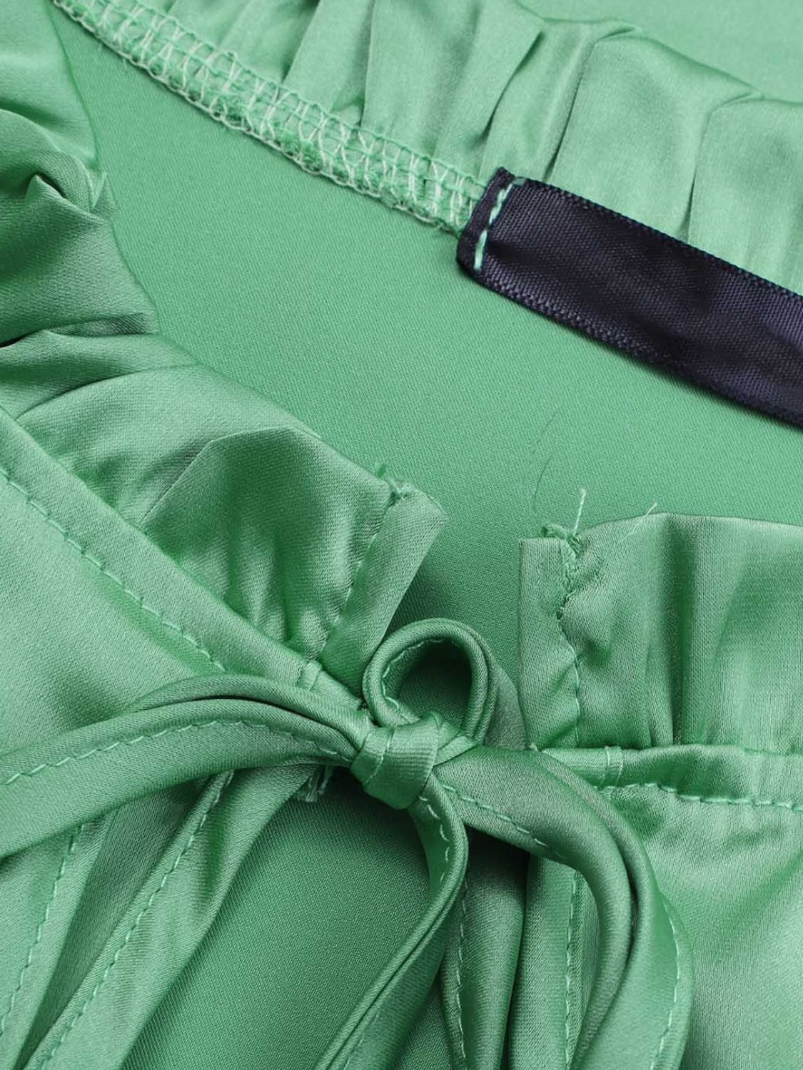 Elegant green blouse featuring frill accents and lantern sleeves.
