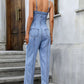 Back view of spaghetti strap denim overalls featuring back pockets.
