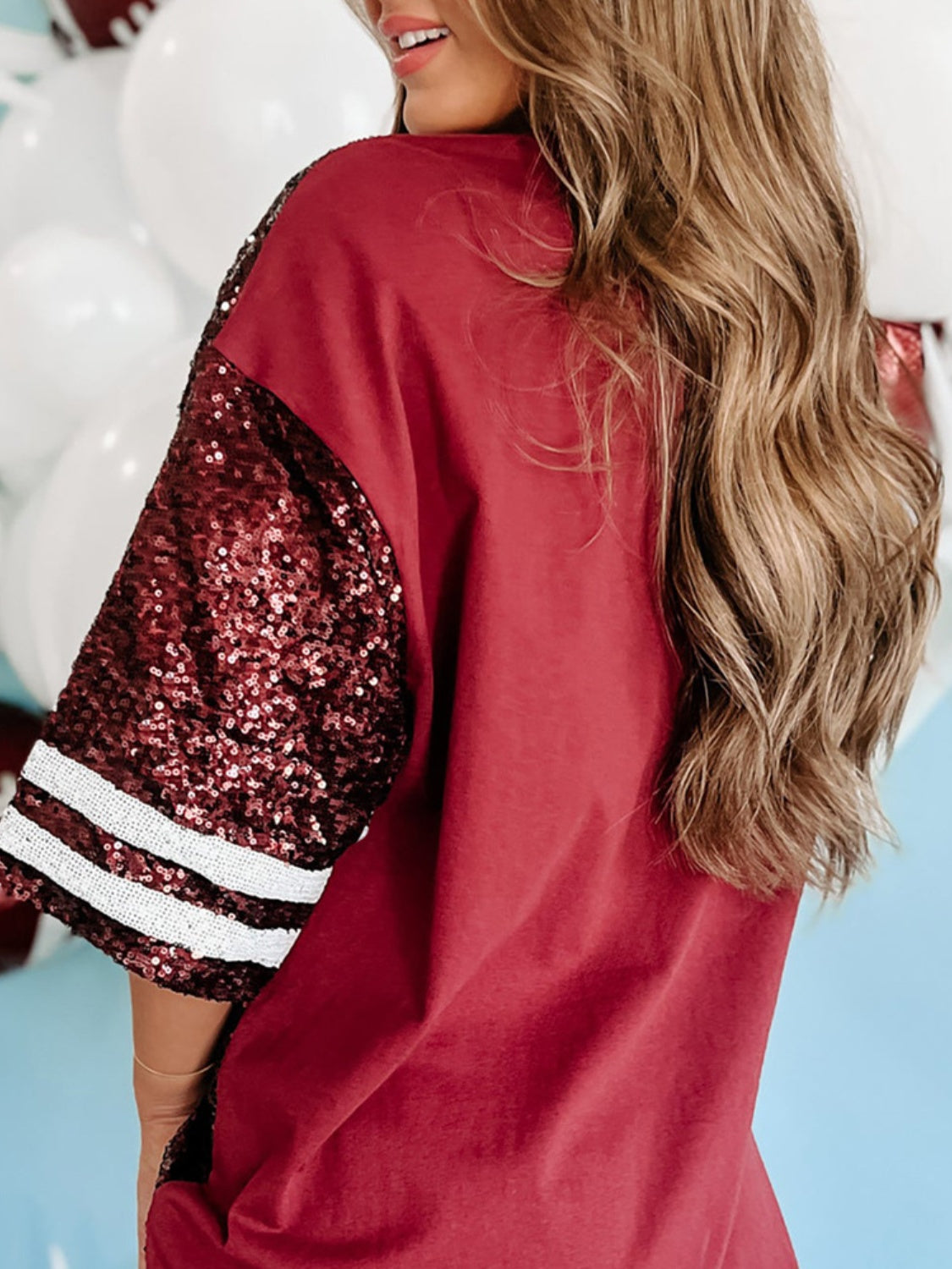 Detailed view of the sequins and football design on a burgundy game day top.