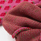 Close-up detail of the strawberry pattern on the pink knit sweater, perfect for adding a touch of whimsy to your outfit.

