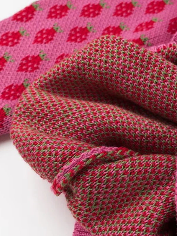 Close-up detail of the strawberry pattern on the pink knit sweater, perfect for adding a touch of whimsy to your outfit.

