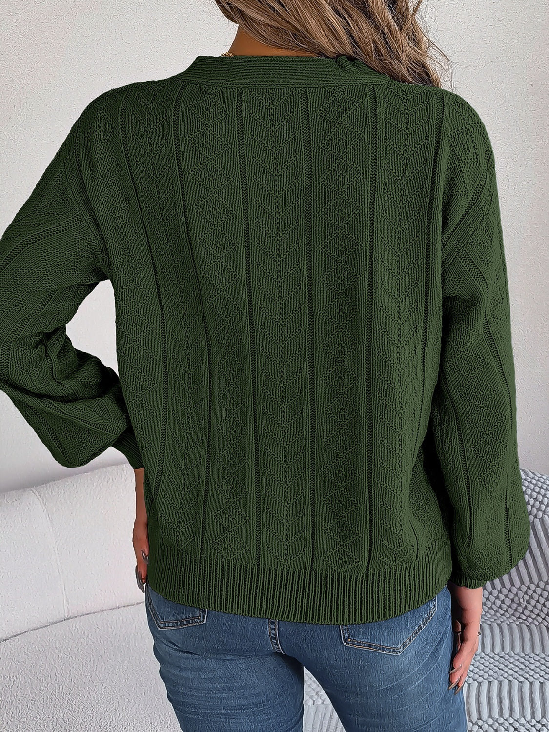 Close-up of cable knit Henley sweater with button detailing in green