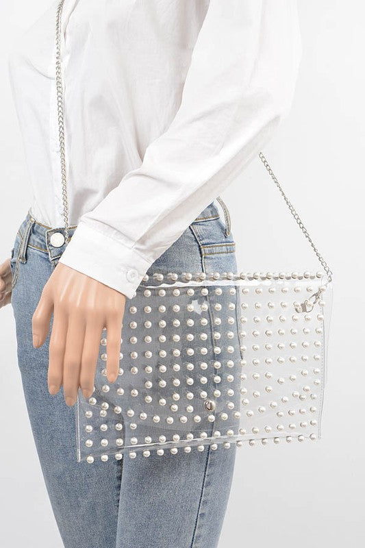 Modern clear bag with pearl studs and silver chain strap.