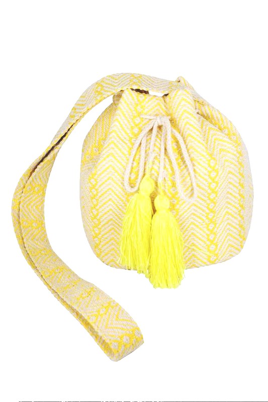 Yellow Aztec bucket bag with playful tassel details and roomy design.
