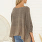 Cozy knit poncho with fringe detailing, offering a versatile layering option.