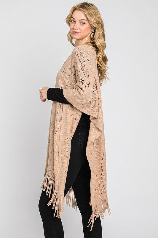 Taupe paisley-pattern knit poncho styled for casual layering.
