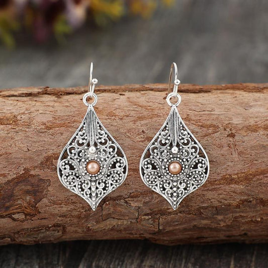 Delicate filigree earrings in teardrop shape with a pearl-like central bead