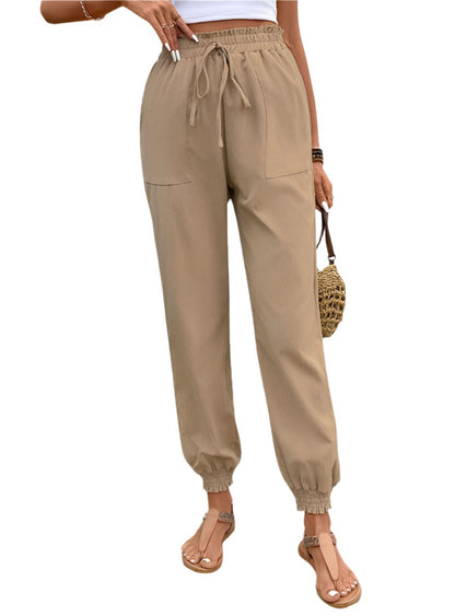 Front view of khaki tied elastic waist pants with side pockets and cuffed ankles
