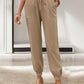 Deep side pockets on khaki tied elastic waist pants with relaxed fit