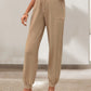 Side view of khaki tied elastic waist pants, styled with casual sandals
