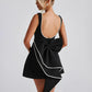 Timeless black A-line dress with elegant pearl accents and bow detailing.