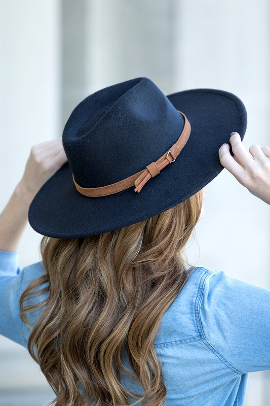 Black wide brim Panama hat with a tassel belt shown from the side profile.
