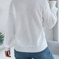 Soft white cable knit sweater styled with modern cutout details