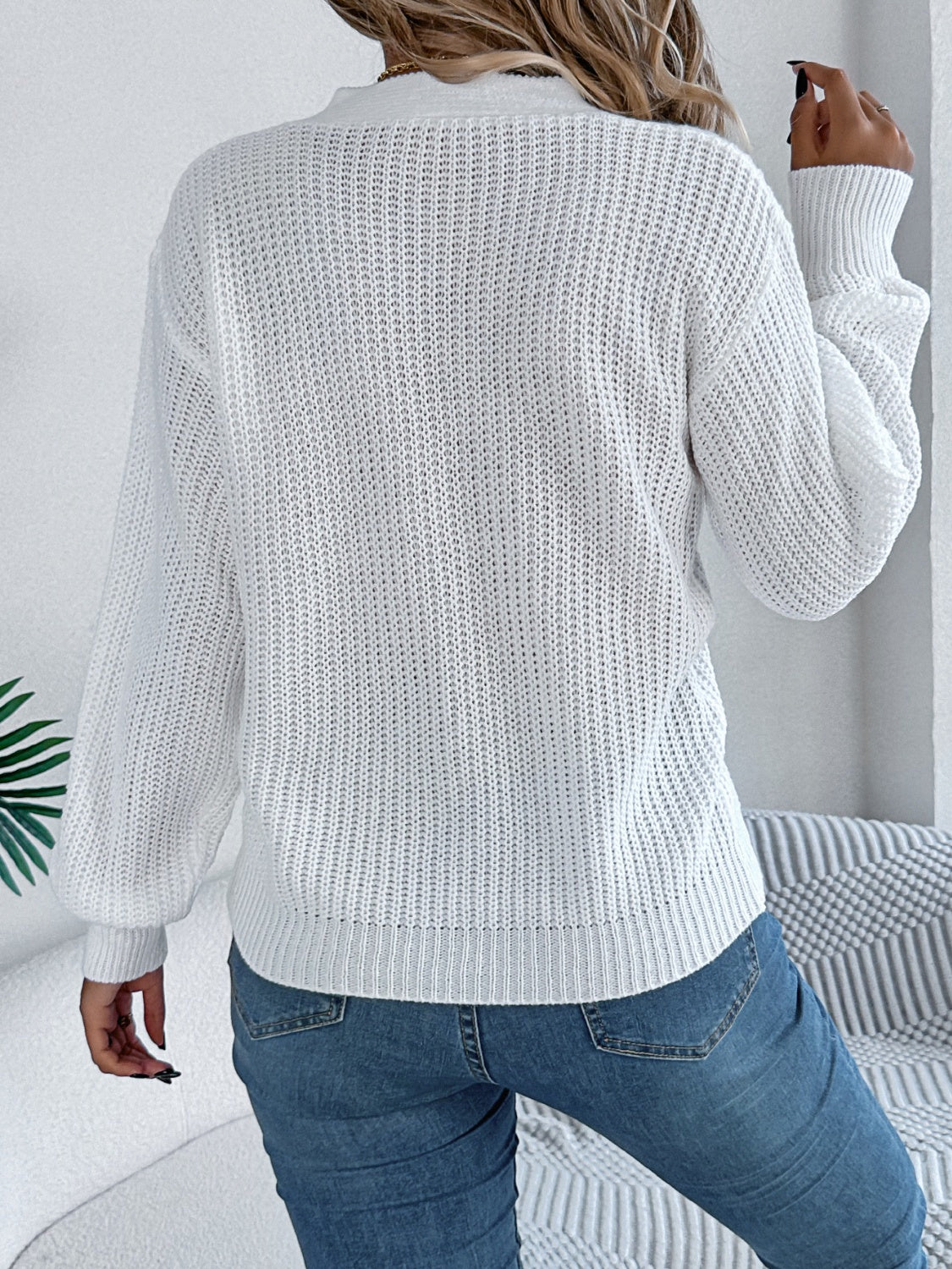 Soft white cable knit sweater styled with modern cutout details