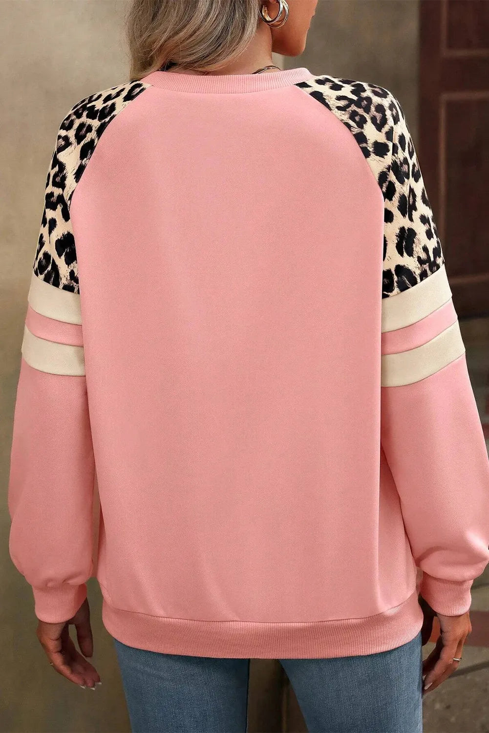 Relaxed-fit sweatshirt in pink with leopard print and striped sleeves for a chic casual look.
