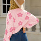 Women’s pink cardigan with white floral detailing
