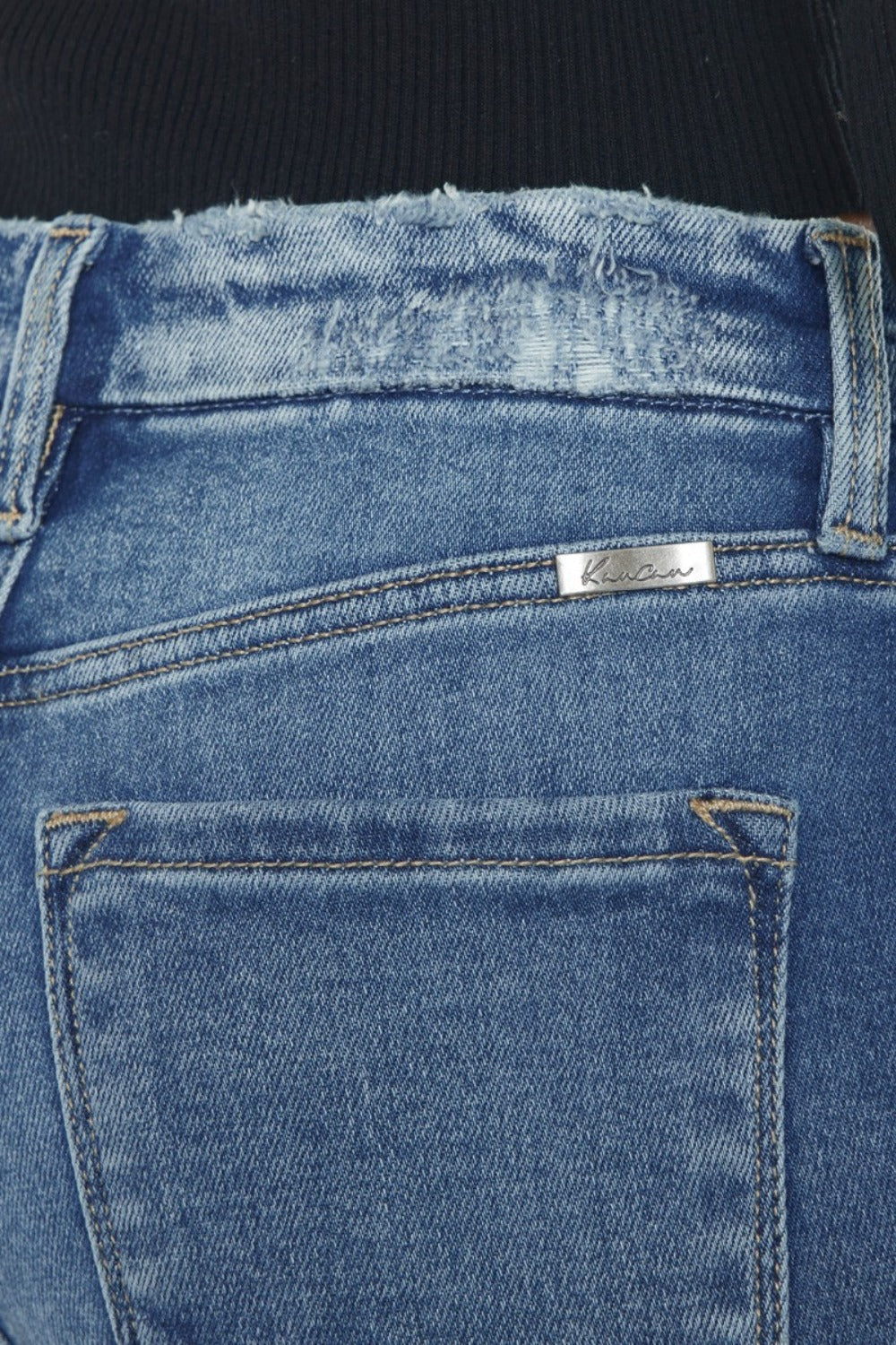 Close-up of wide waistband and slim fit on Kancan jeans.
