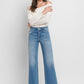 Close-up of high-rise slim wide-leg jeans in medium wash.
