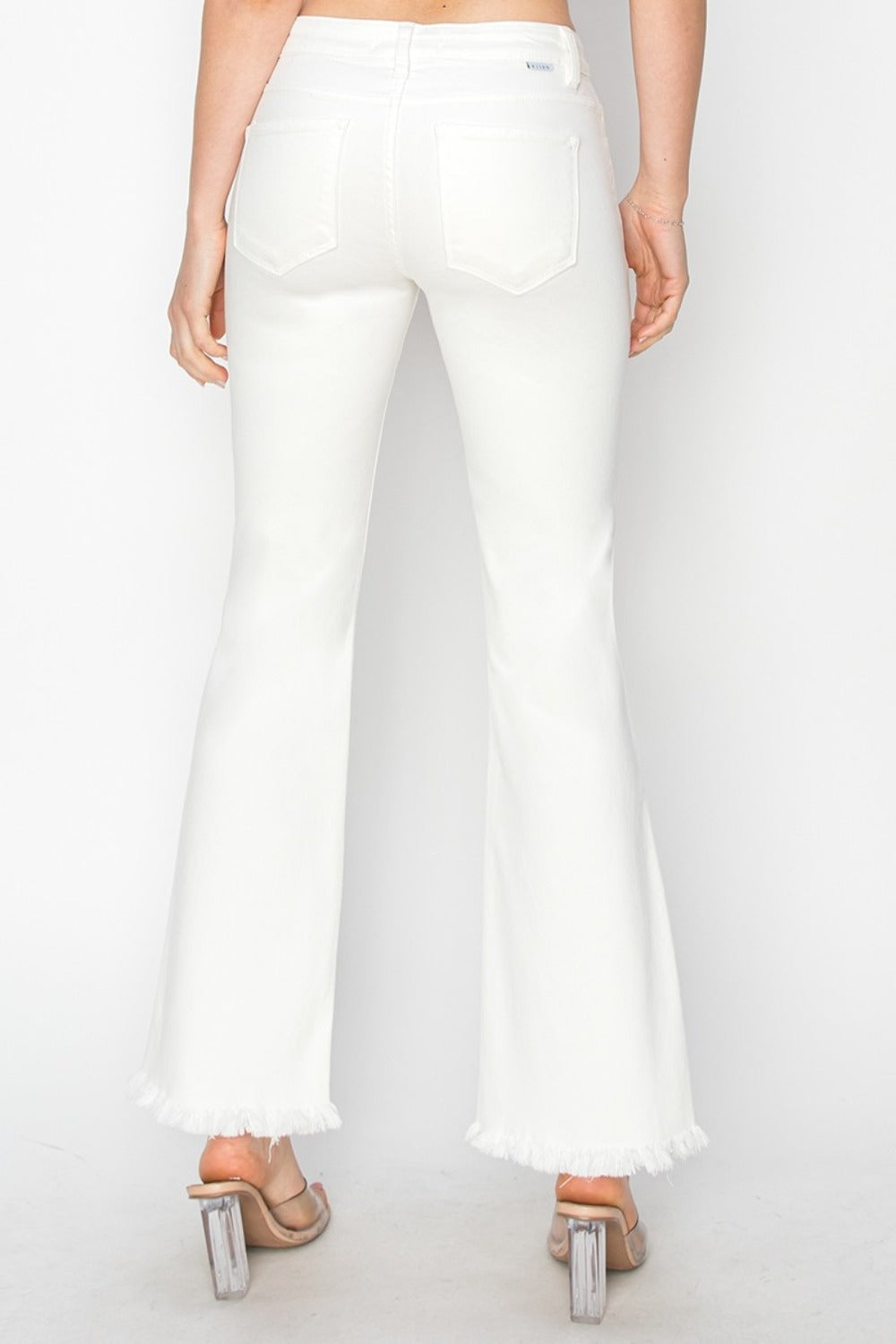 Modern step hem detail on RISEN white flare pants.
