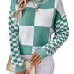 Woman wearing a turquoise checkerboard patchwork sweater with checkered sleeves.
