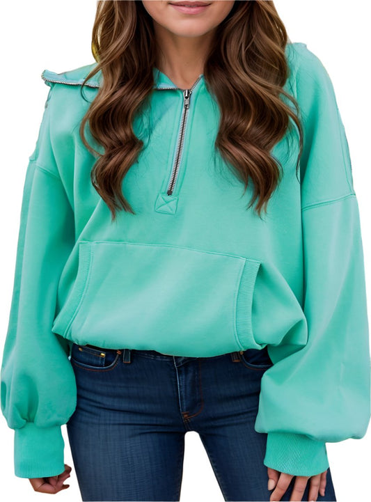 Women's oversized turquoise half zip hoodie with kangaroo pocket.
