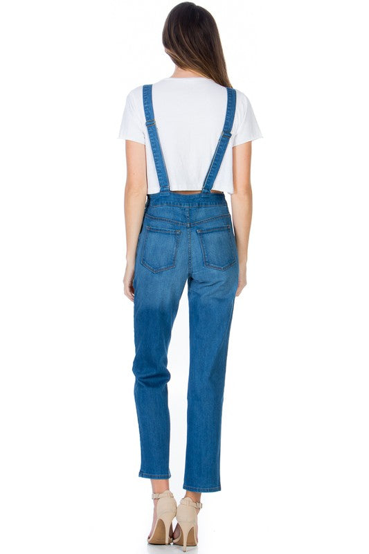 Back view of medium wash denim overalls with two back pockets.
