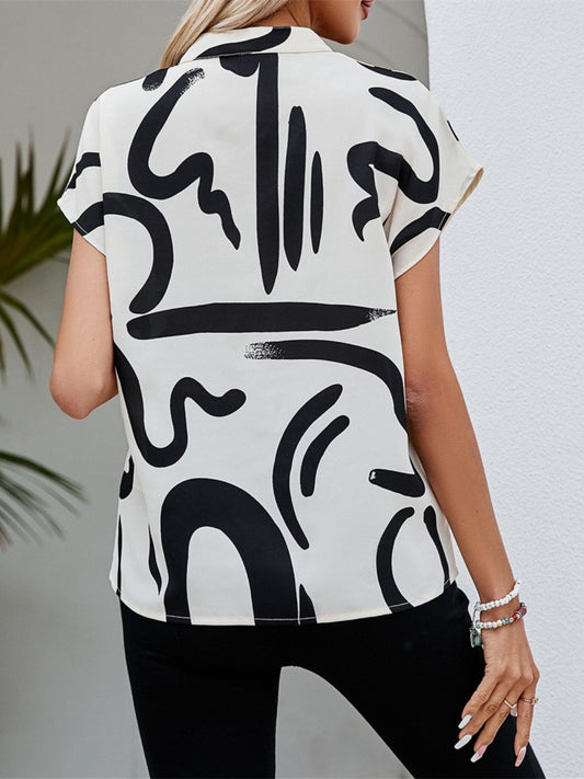 Elegant black-and-white abstract blouse paired with casual pants for a day out
