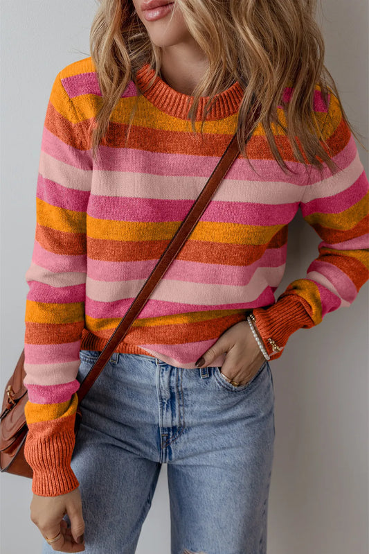 Vibrant orange and pink striped sweater paired with denim for a fun fall look