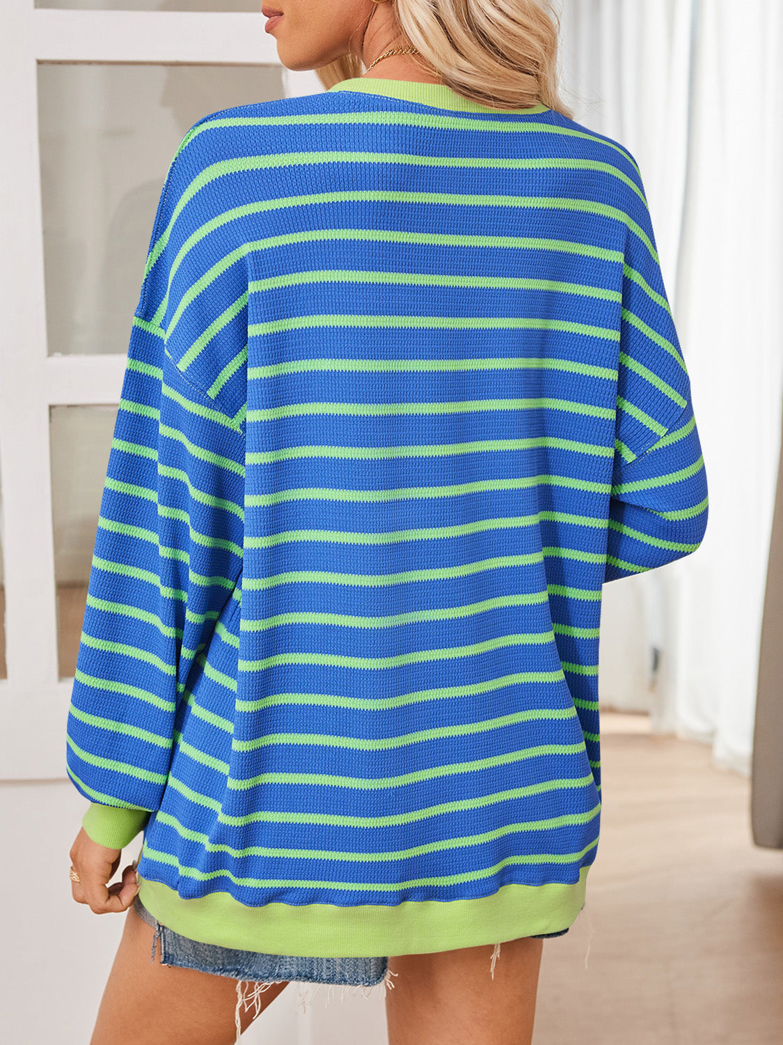 Retro-inspired blue pullover with green stripes for a vintage vibe.
