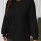 Black waffle-knit sweatshirt with a relaxed fit and side buttons for women.
