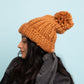 Cozy brown knit beanie with a chunky cable design for a trendy winter look
