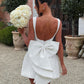 Sophisticated white party dress with romantic bow design

