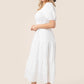 Whimsical white tiered midi dress with a comfortable, flowy fit.
