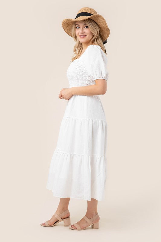 Whimsical white tiered midi dress with a comfortable, flowy fit.
