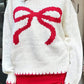 Front view of a white bow-knot knit sweater, perfect for cozy winter days with a fun bow design.

