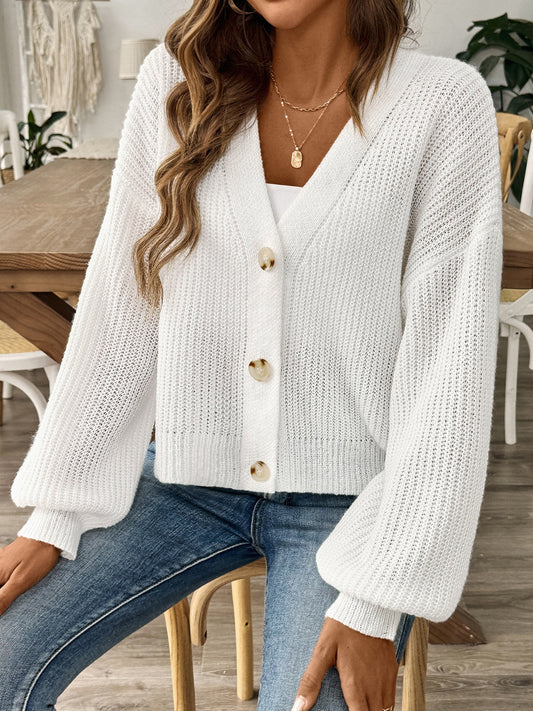 Close-up of white ribbed knit cardigan with oversized buttons
