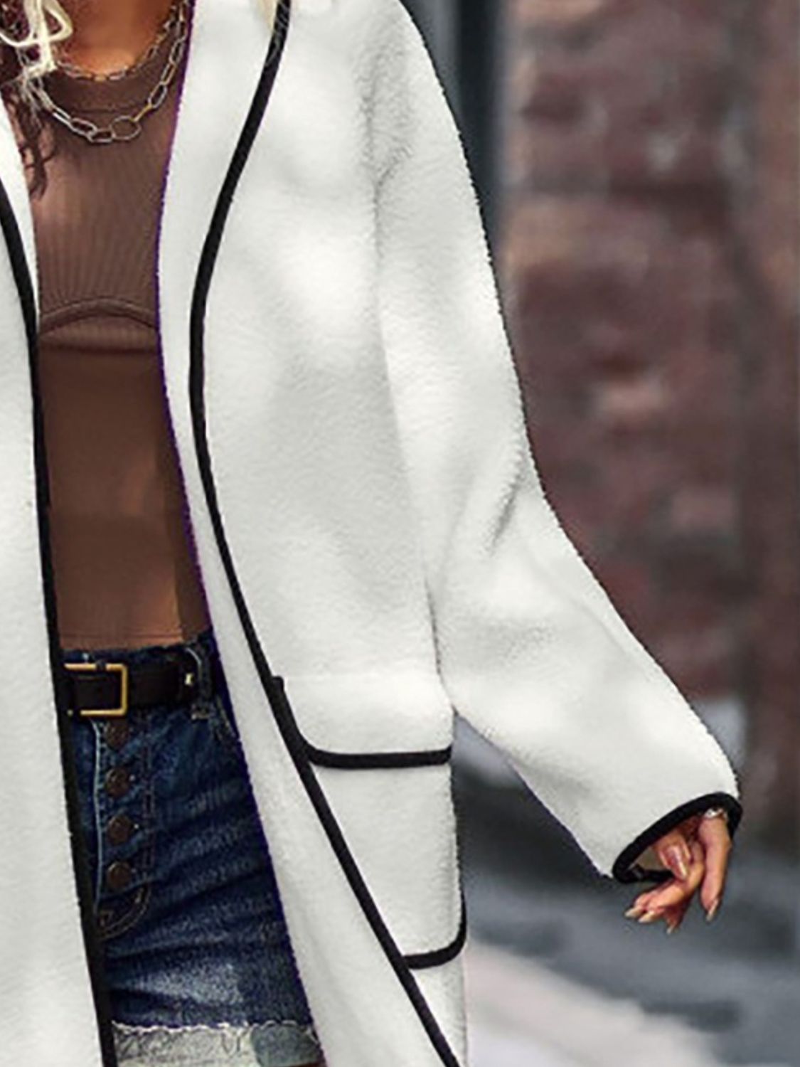 Modern white long sherpa coat with black trim, perfect for stylish layering.
