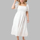 White smocked puff sleeve midi dress with a flowing tiered skirt.
