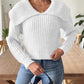 Woman wearing a white cable-knit wide collar sweater with jeans.
