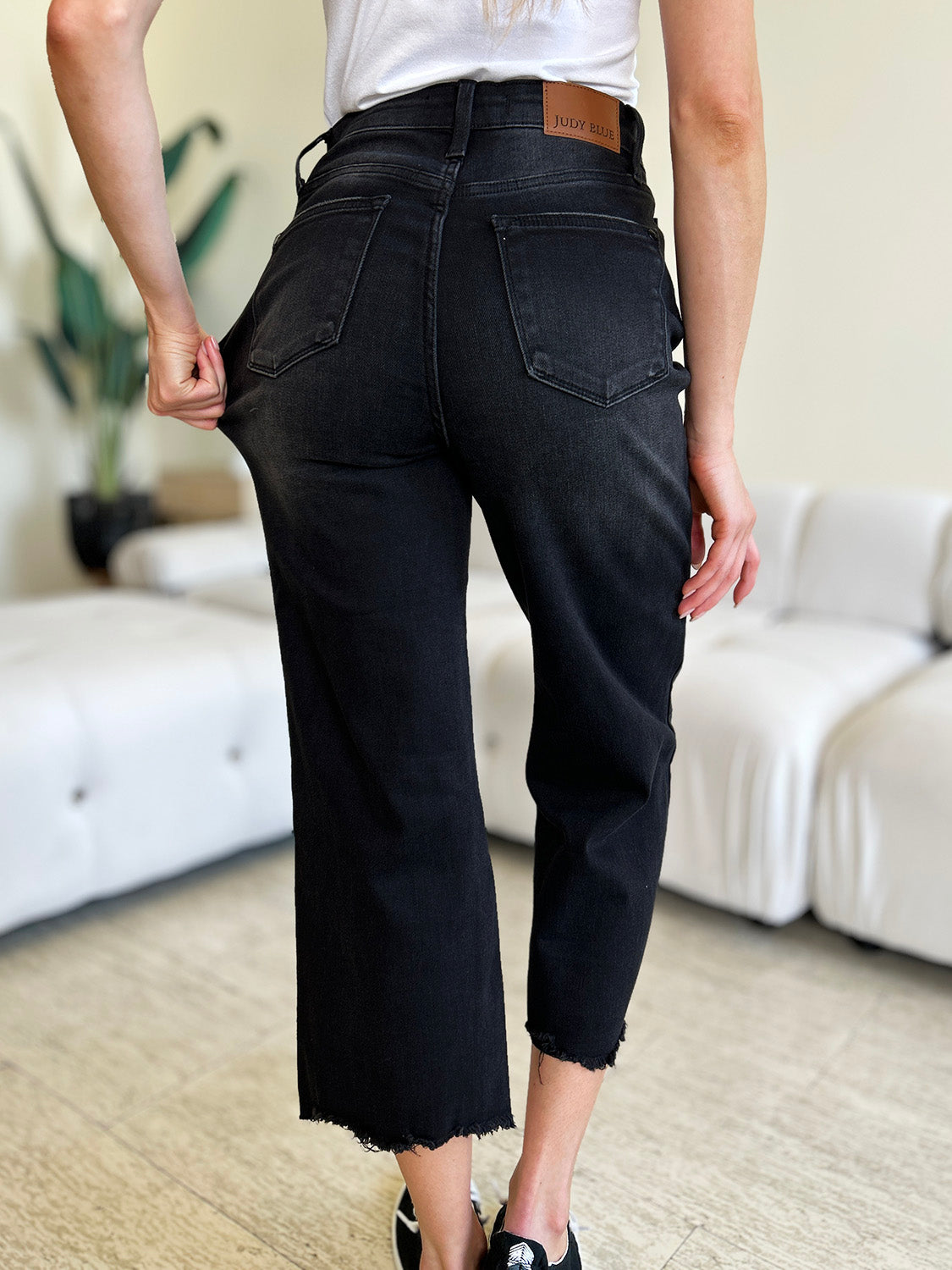 High waist denim with button fly closure, cropped leg style.