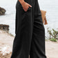 Black wide-leg pants with smocked high waist for plus size women.
