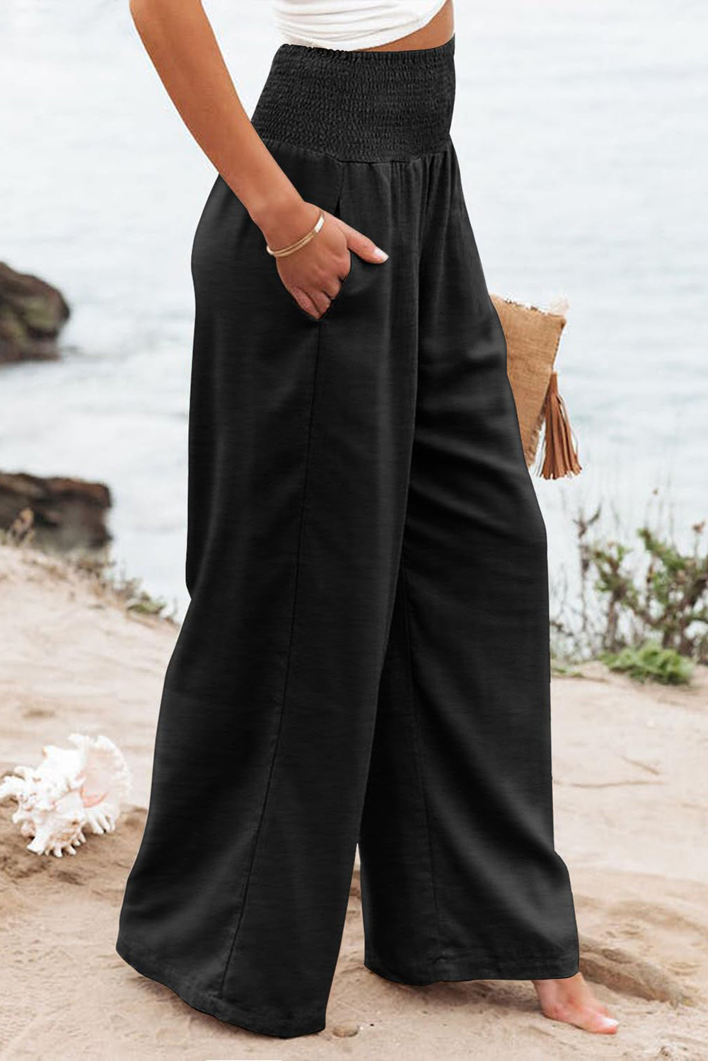 Black wide-leg pants with smocked high waist for plus size women.
